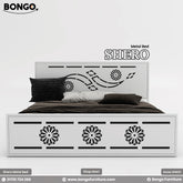A product photo of the "SHERO Metal Bed" by Bongo Furniture. The white bed frame has a large metal with a central laser-cut design and a footboard decorated with three matching circular, mandala-like cutouts.
